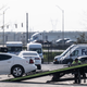 A tow truck hauls a car out a parking lot